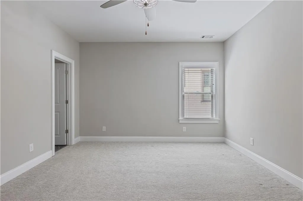 Carpeted spare room featuring ceiling fan