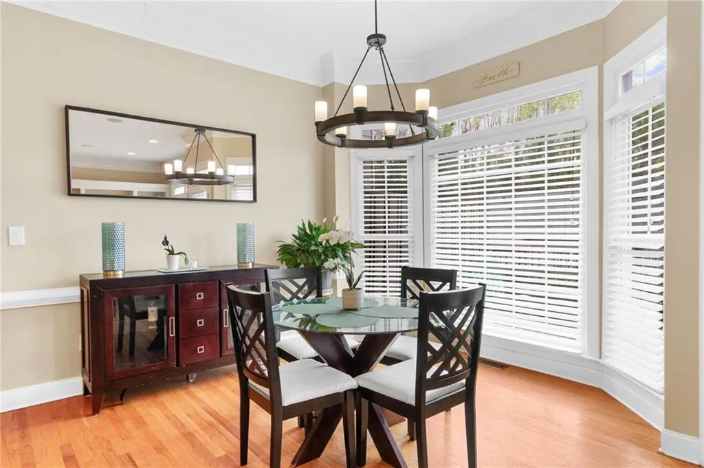 Dining area featuring ornamental molding, hanging lights, and light wood-type flooring