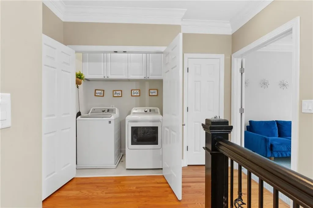Laundry area featuring crown molding, light wood-style floors, and washer and dryer