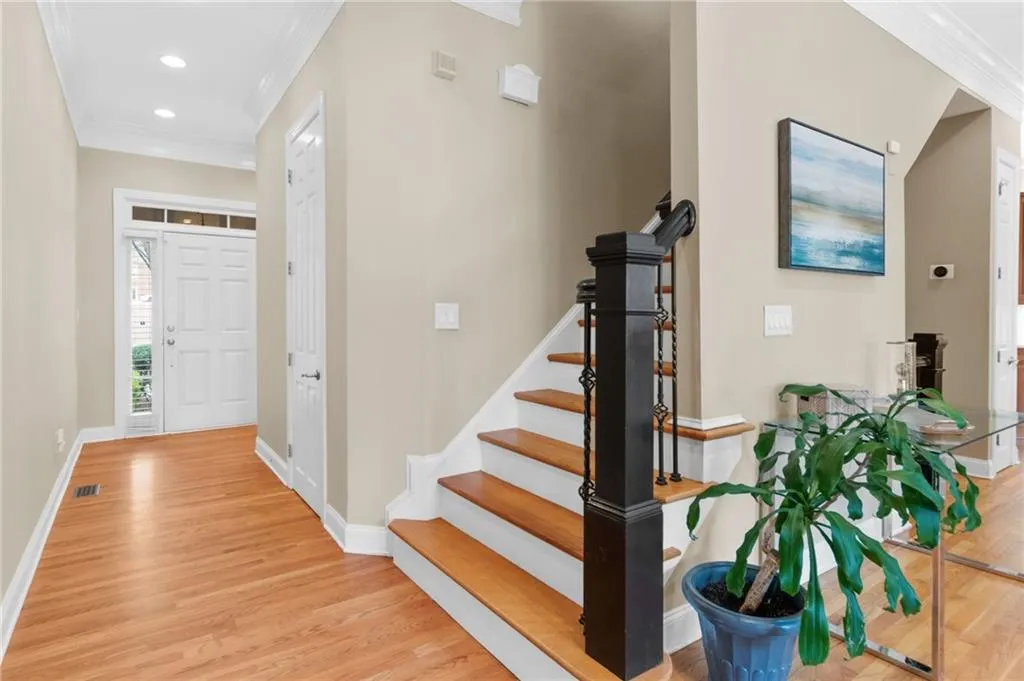 Foyer entrance with crown molding, light wood finished floors, and recessed lighting
