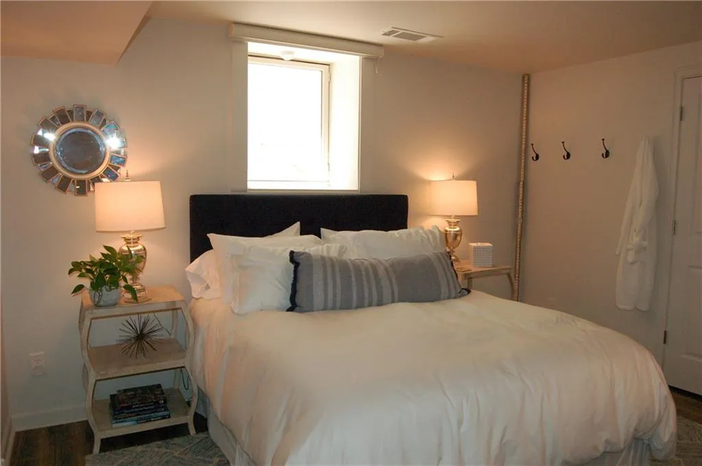 Lower level bedroom with electric, remote control shade over window.