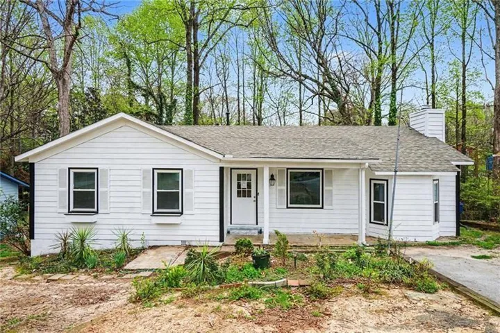 White siding exterior with black-framed windows and white shutters