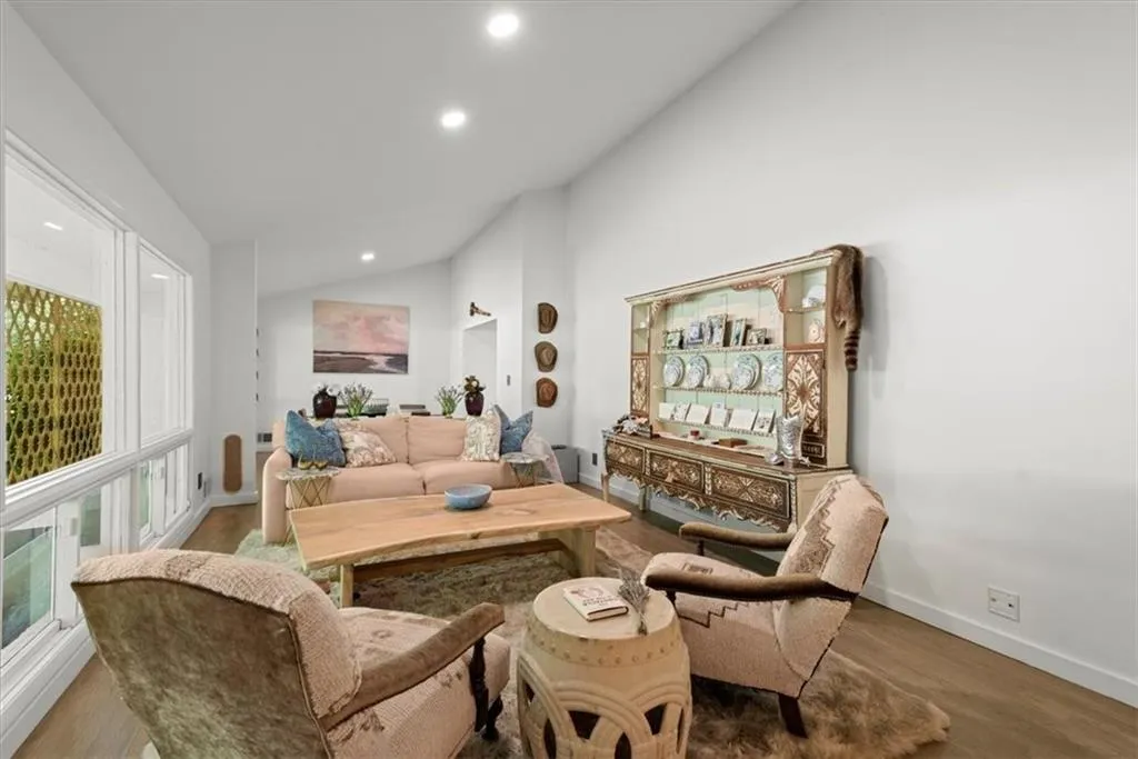 Living room open to dining room with vaulted ceiling
