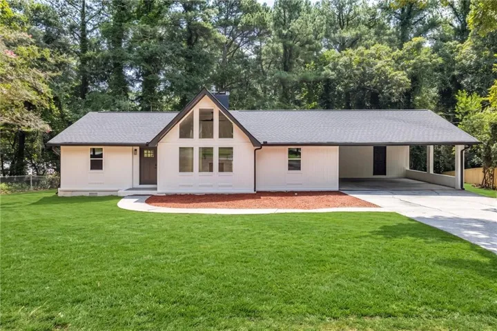 White exterior with a dark-pitched roof and a prominent A-frame window design