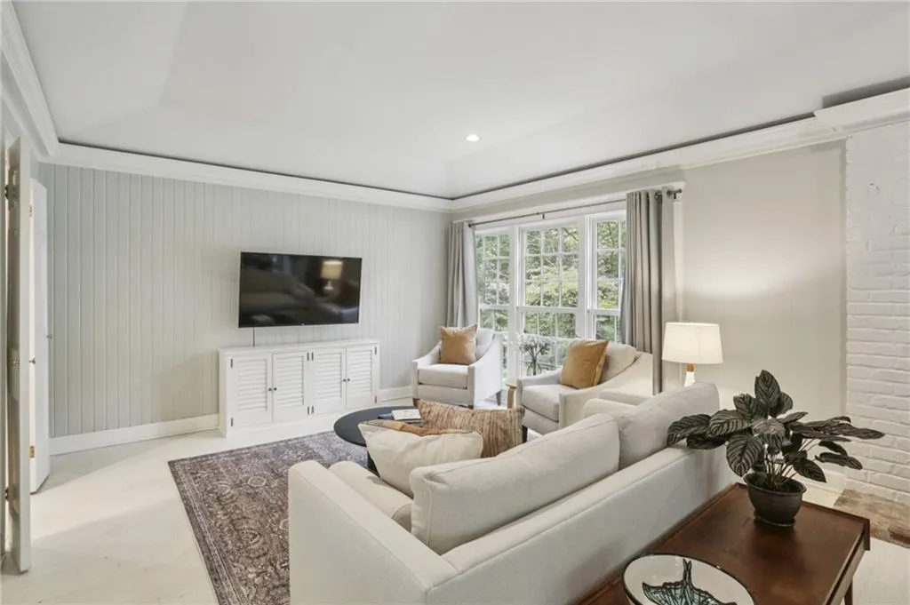 This living room embodies modern charm with its functional floor plan and stylish features. Recessed lighting highlights the space, while ample natural light brings warmth and vibrancy, making it a perfect gathering spot.