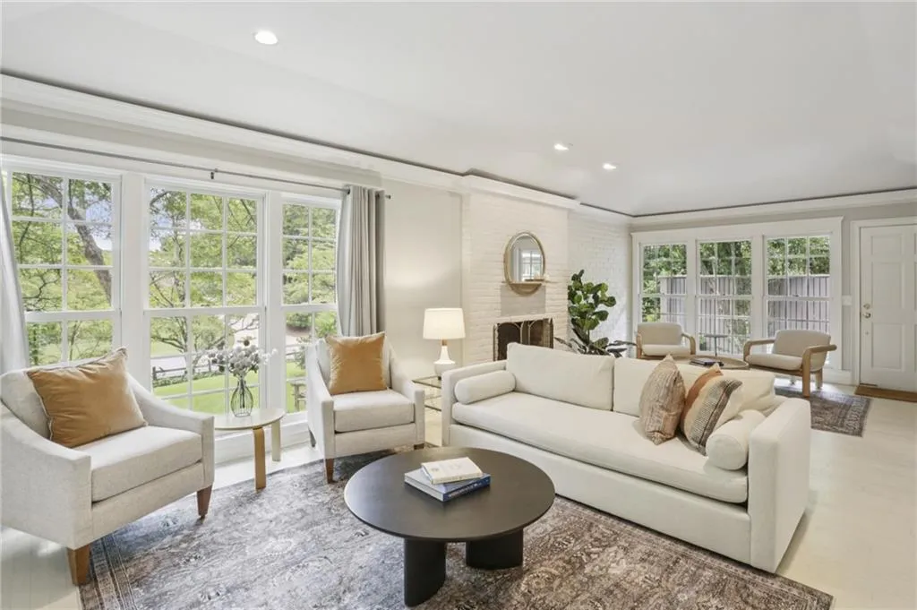 Warm and inviting living space where the outdoor beauty of nature is drawn in through the abundance of floor to ceiling windows, creating a cozy, yet light filled, space to relax.