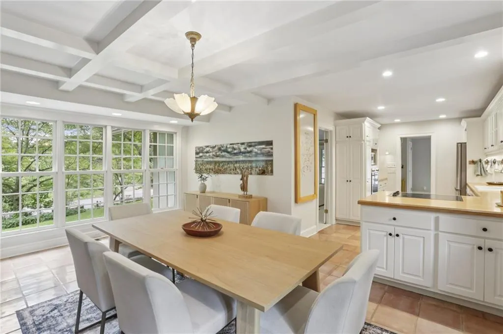 A wealth of natural light streams in through the wall of windows. Elegant yet functional dining space, open to the kitchen providing easy engagement with family and guests.