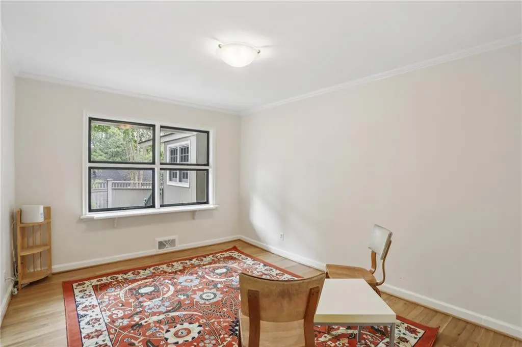 Guest bedroom with ample light and beautiful light finished hardwood floors.