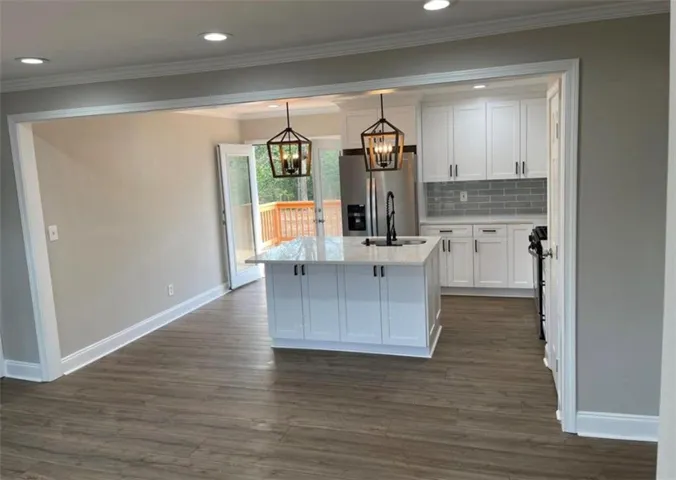 Kitchen island with a light-toned countertop and pendant lighting
