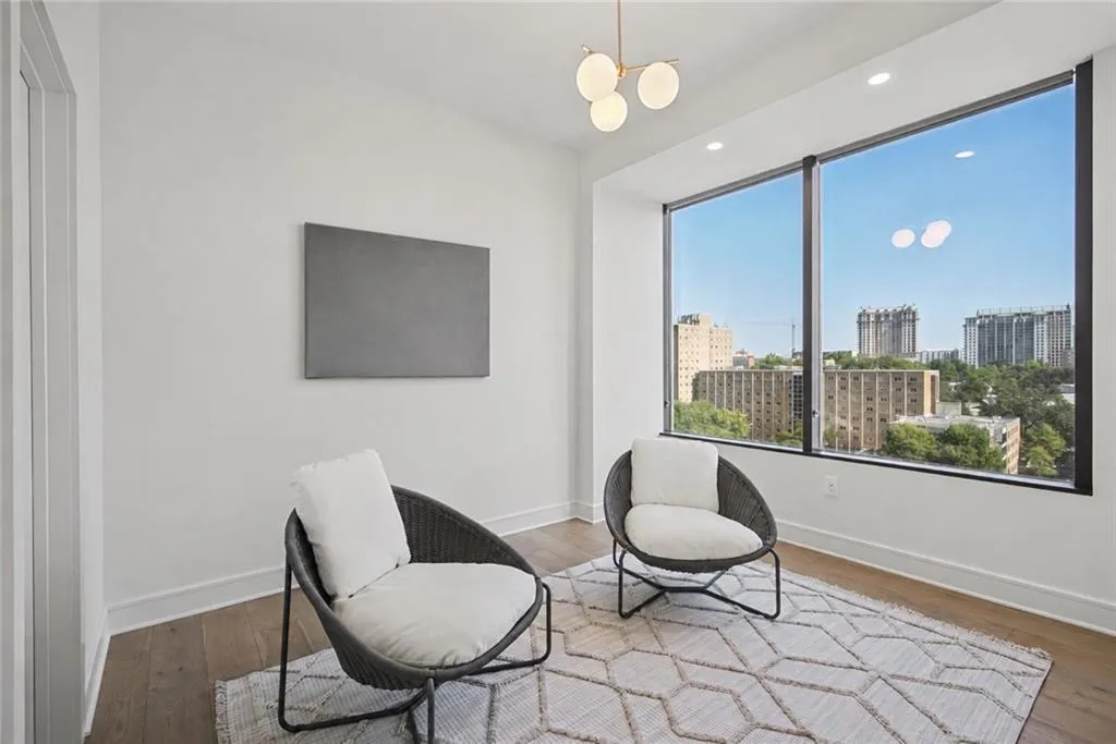 Expansive floor-to-ceiling window, wood-finish flooring, recessed lighting, and a contemporary chandelier
