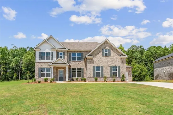 Two-story exterior with a mixed material facade featuring brick and horizontal siding, gabled rooflines, dark shutters, and a covered entry