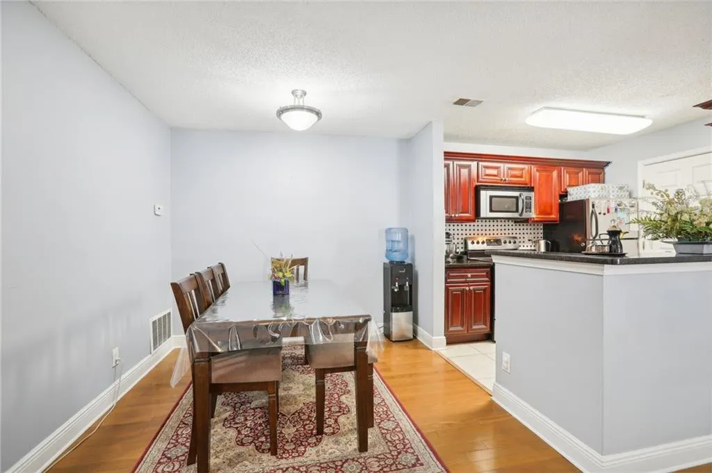 Dining space with light hardwood / wood-style flooring and a textured ceiling