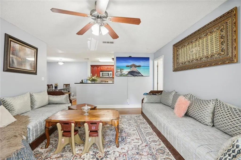 Living room featuring ceiling fan and hardwood / wood-style floors