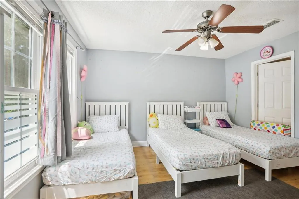 Bedroom with hardwood / wood-style floors and ceiling fan
