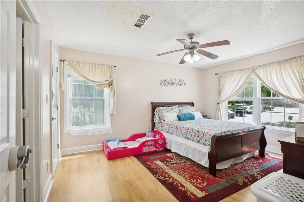 Bedroom featuring ceiling fan, a textured ceiling, and hardwood / wood-style flooring