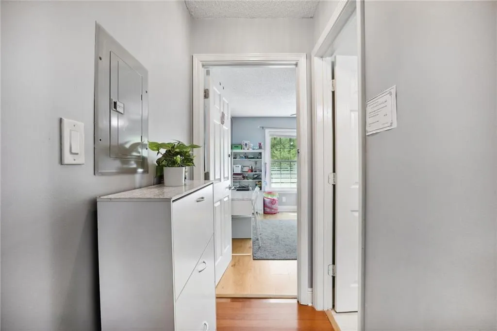 Hallway featuring a textured ceiling and light wood-type flooring