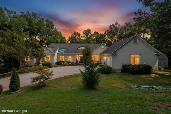 Stucco exterior with a peaked roofline, an integrated two-car garage, and a covered front entry