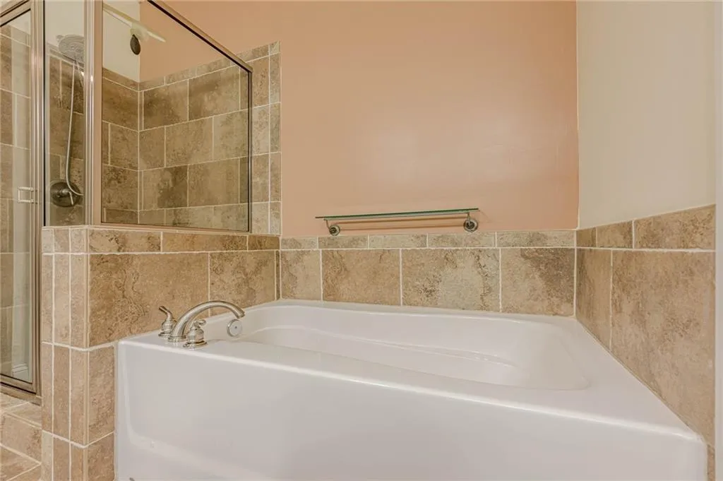 Bathroom featuring a bath and a stall shower