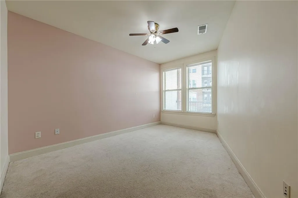 Unfurnished room featuring light colored carpet and a ceiling fan