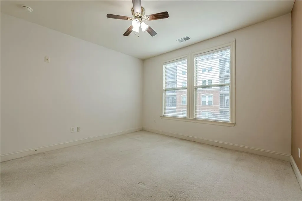 Spare room featuring carpet and a ceiling fan