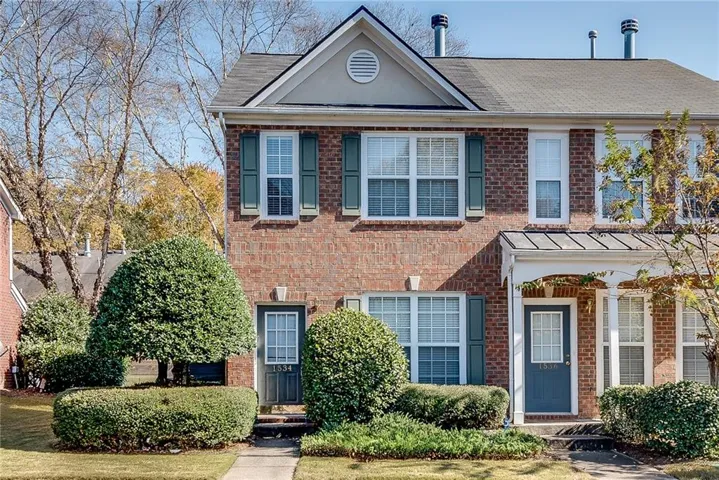 Brick facade with gray-shingled roof and decorative gable