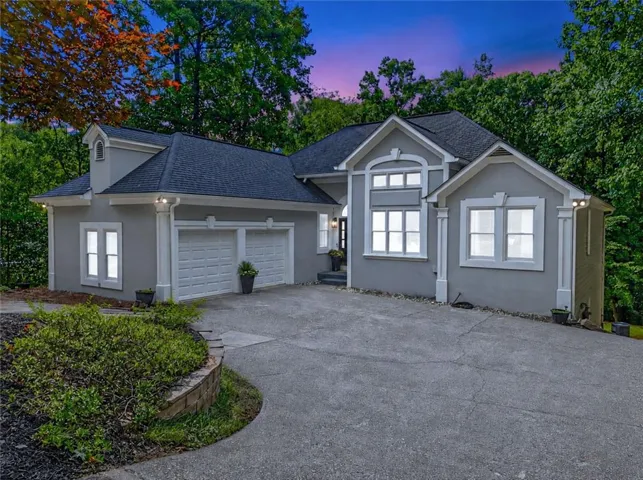Contemporary home with a two-car garage, stucco exterior, multiple gables, and a dormer
