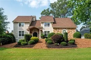 Traditional home featuring a front yard and stone siding