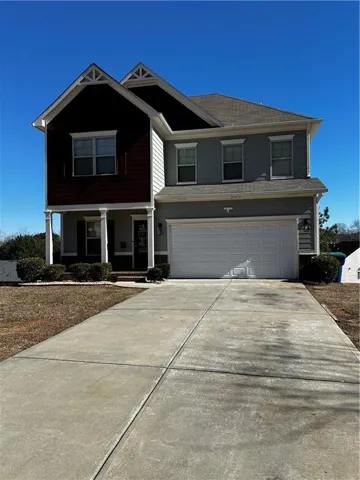 Two-story residence featuring a two-car garage, covered porch with columns, and a concrete driveway