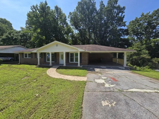 Brick exterior with a covered front porch, columns, and a paved walkway