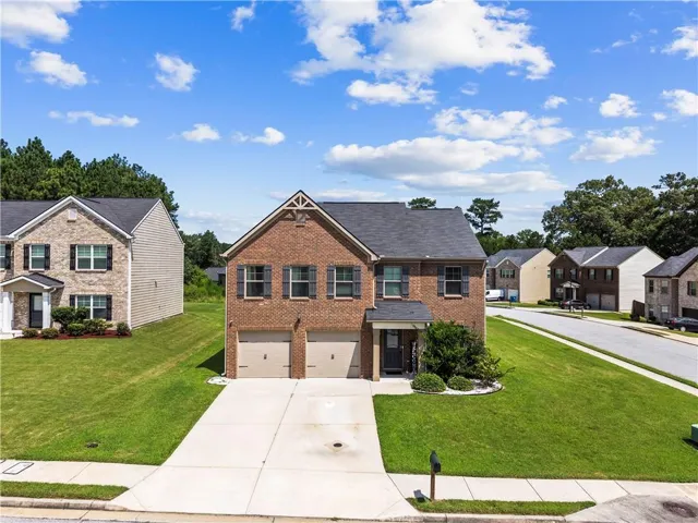 Brick exterior, two-car garage, established landscaping, concrete driveway, and sidewalk