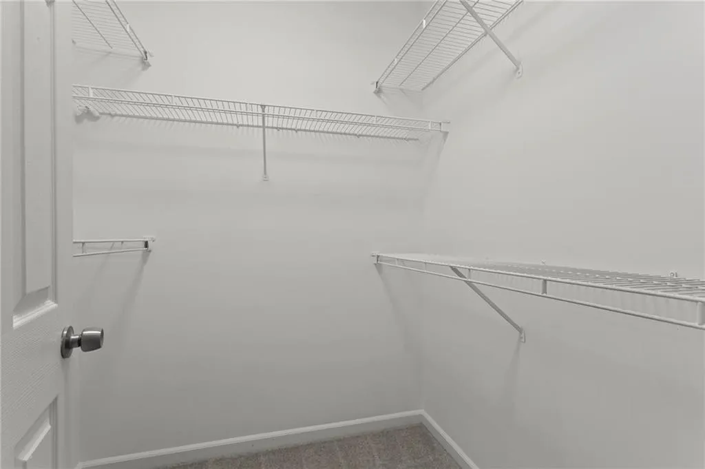 Spacious closet with light colored carpet
