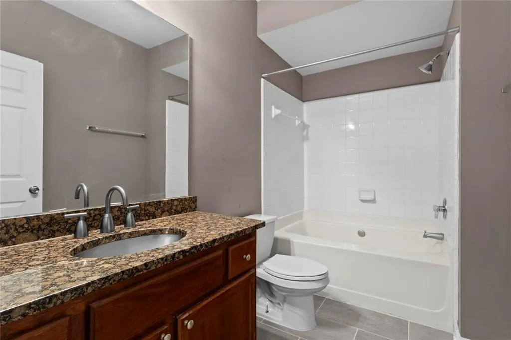 Full bath with shower / bathtub combination, vanity, and light tile patterned floors