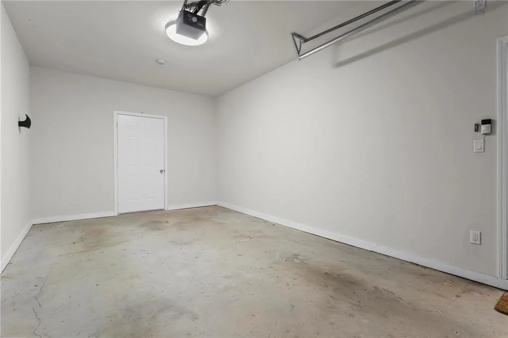 Garage with baseboards and a garage door opener