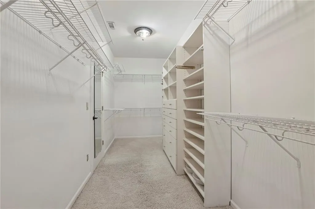 Walk-in closet in primary bedroom with custom closet organizers