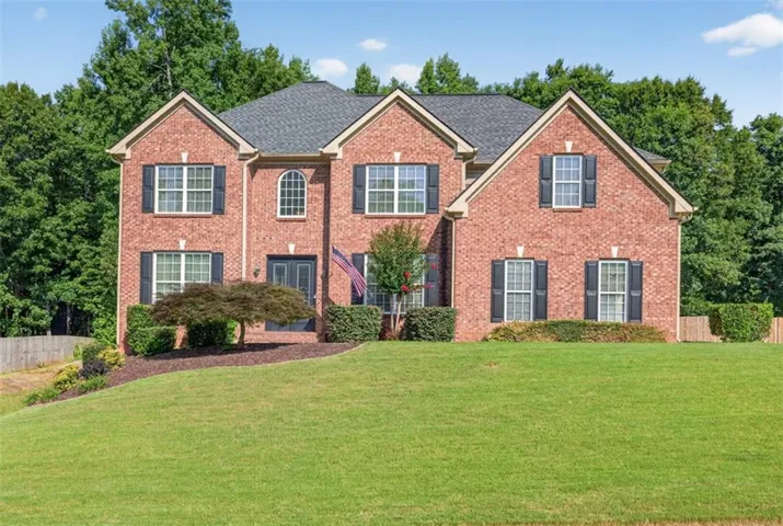 Two-story brick exterior featuring multiple gables, dark shutters, and an arched window accent