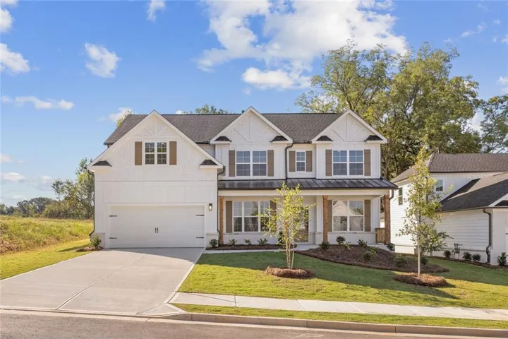 Two-story residence featuring a dark shingle roof, white siding, and decorative brown shutters