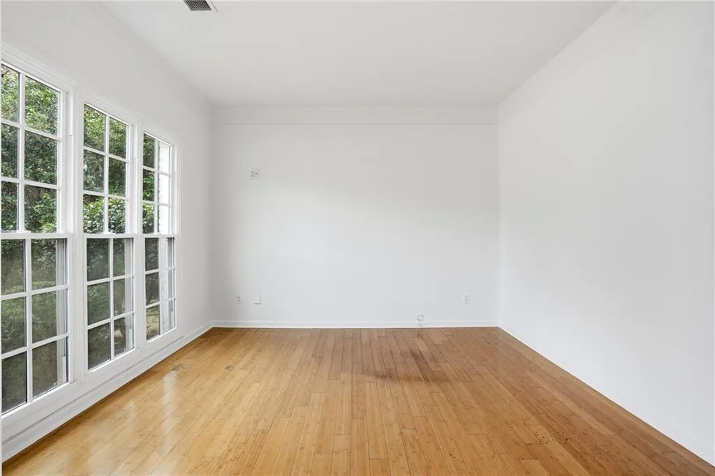 Empty room with light wood finished floors and crown molding