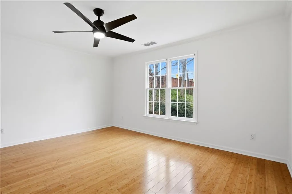 Unfurnished room featuring ornamental molding, light wood finished floors, and ceiling fan