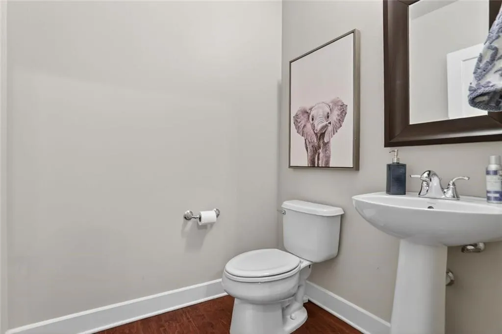 Half bath featuring baseboards and dark wood-type flooring