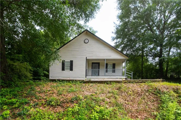 White siding exterior with a covered front porch featuring white railings