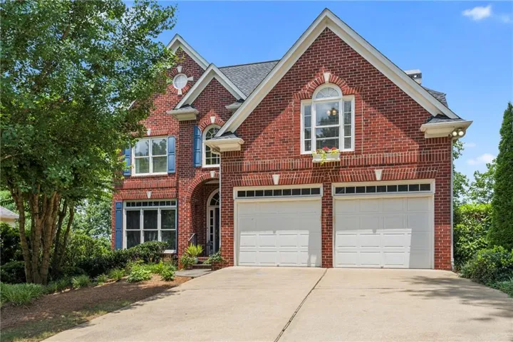 Brick exterior featuring a multi-gabled roofline and a two-car garage