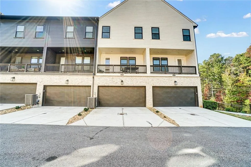 Back of property with a balcony and concrete driveway