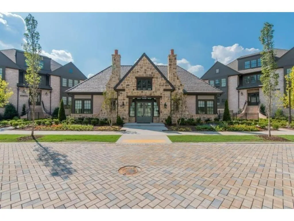 View of front of home featuring a chimney, french doors, and stone siding