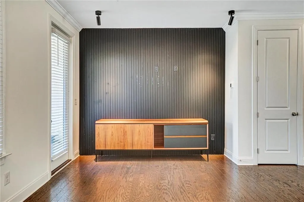 Unfurnished bedroom with wood finished floors and ornamental molding