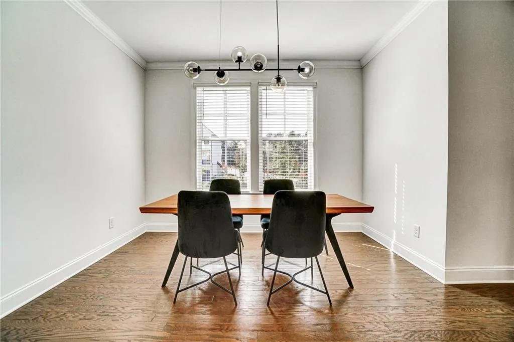 Dining room with crown molding and dark wood-type flooring