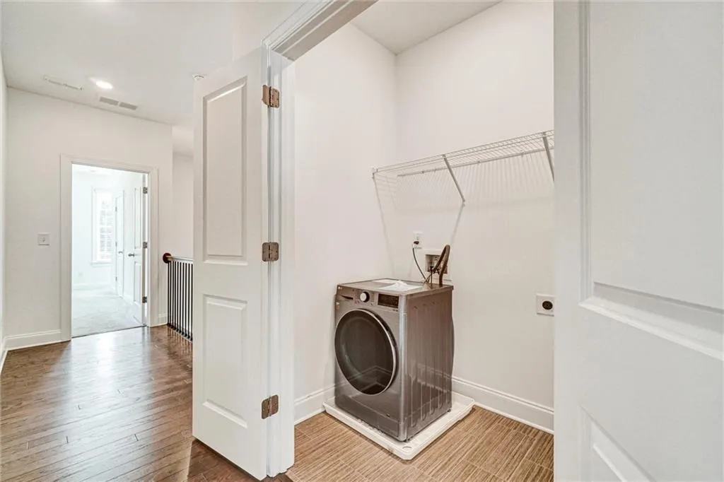 Laundry area featuring washer / clothes dryer and wood finished floors