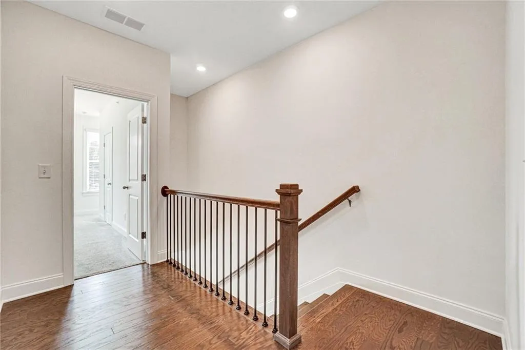 Stairway with wood finished floors and recessed lighting