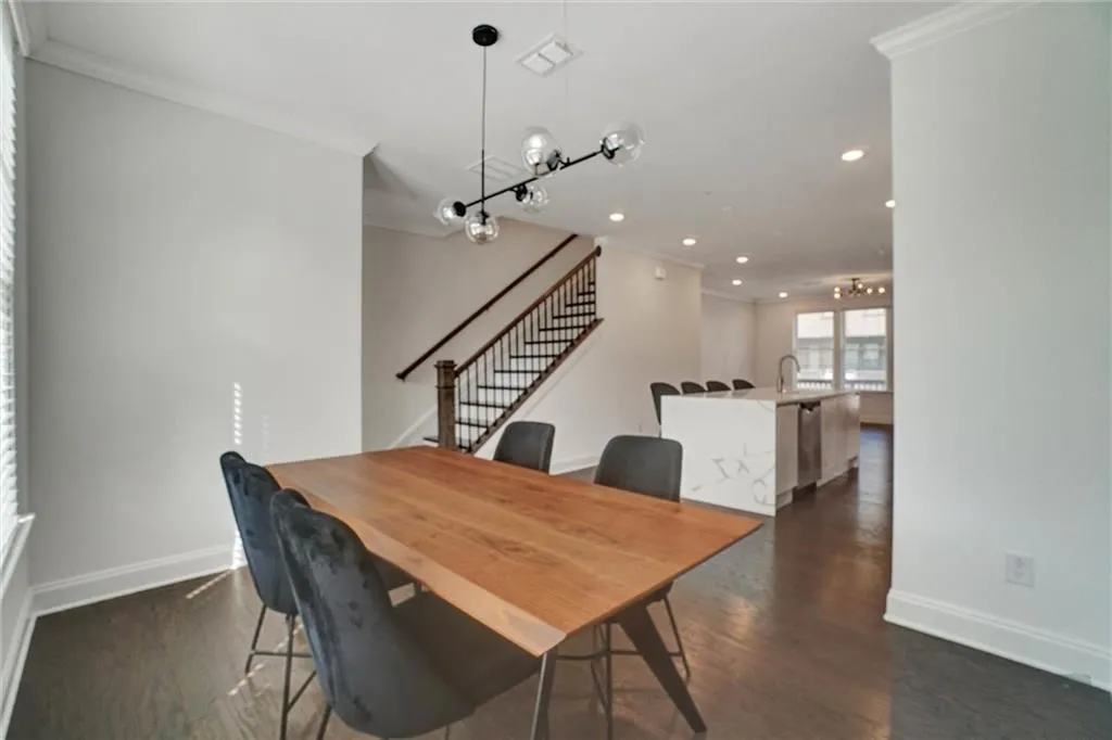 Dining area with stairway, crown molding, dark wood-style flooring, and recessed lighting