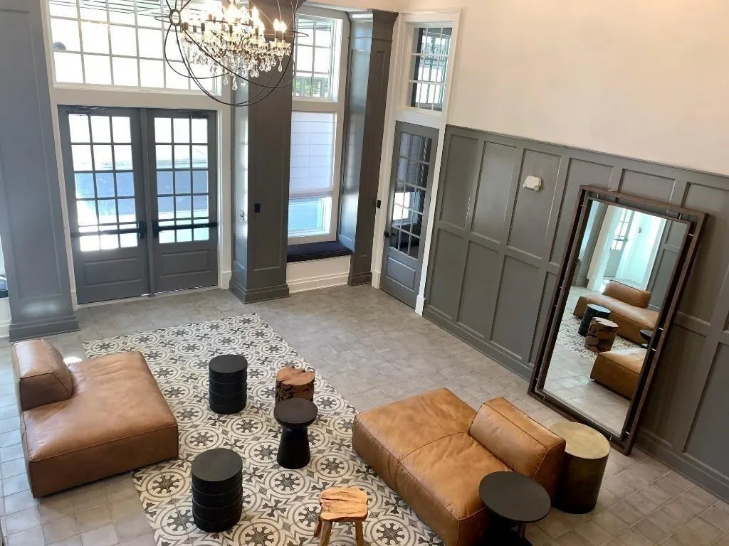 Entryway featuring a decorative wall, french doors, a chandelier, and wainscoting
