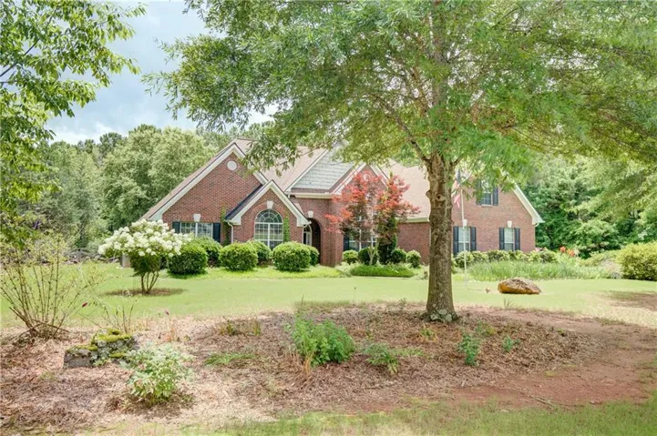 Traditional brick exterior with a gabled roof, arched window, and dark shutters